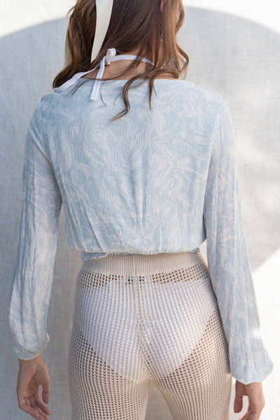 The lightweight gauze material offers ultimate comfort while the knot detail and plunge neckline add a touch of style. With long sleeves and a relaxed fit. light blue.