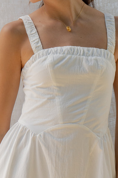 emilia flared mini dress has square neckline and flared silhouette. smocking on the back and adjustable back tie. comes in lemon and white.