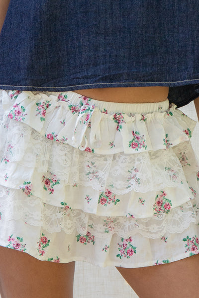 Floral tiered mini skort. Crafted with an elastic waistband and ruffle detail. Shorts have lining that provides coverage.