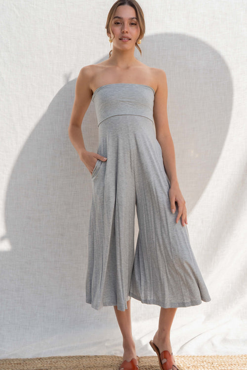 The strapless square neckline and fitted stretch material accentuate the body, while the cropped palazzo bottoms add a touch of trendiness. grey color.