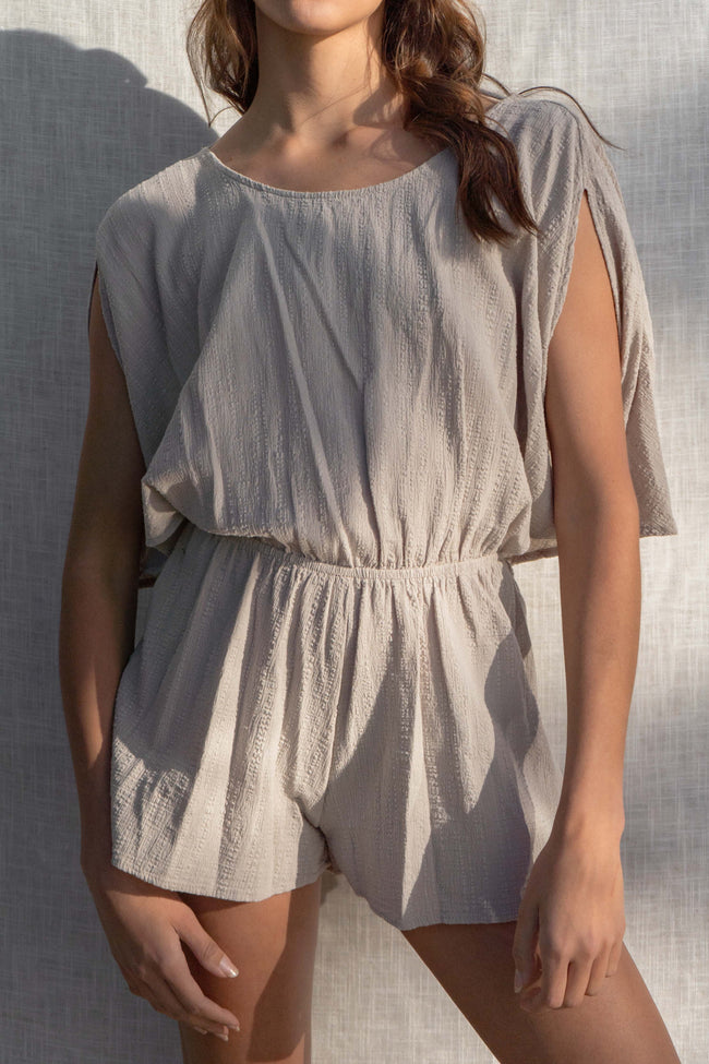 With short sleeves and an elastic waistband, this romper is perfect for any vacation or day in the sun. The open back and linen details add a touch of fun to this must-have piece. taupe color.