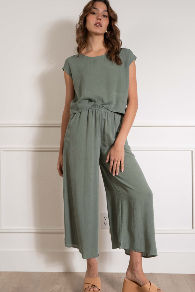 With a loose fit and relaxed style, it provides both comfort and style. The linen detail and short sleeves give it a unique touch, while the crew neckline adds a classic element. dark sage color.