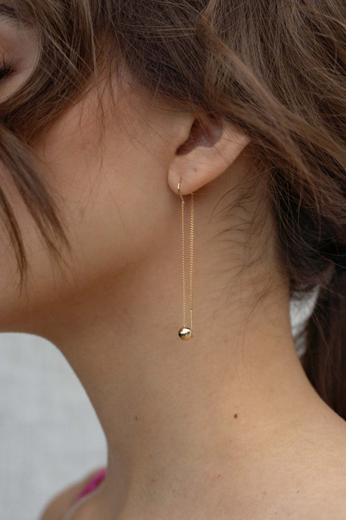 These dainty gold earrings feature a playful ball threader detail