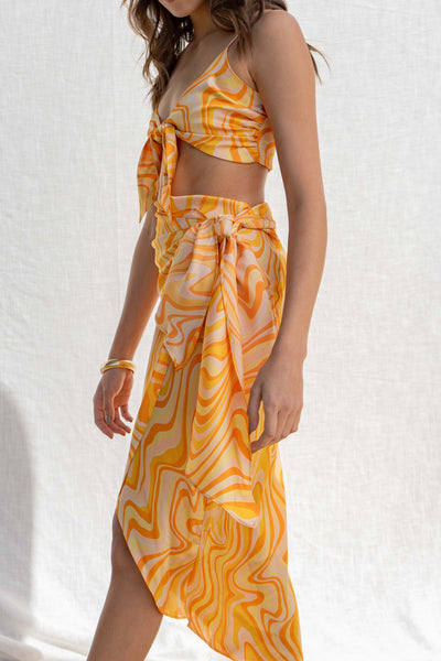 Crafted with a tie front bodice and vibrant, unique print, it's perfect for making a statement on sunny days.