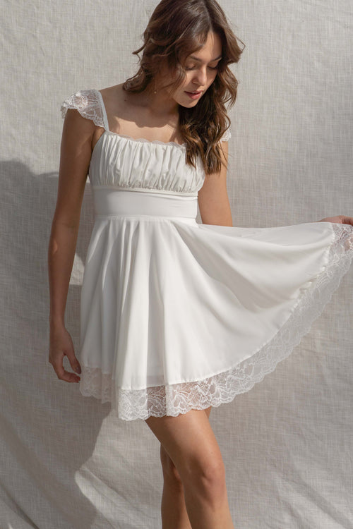 This mini dress features lace straps and trim, with a smocked bodice for a flattering fit.