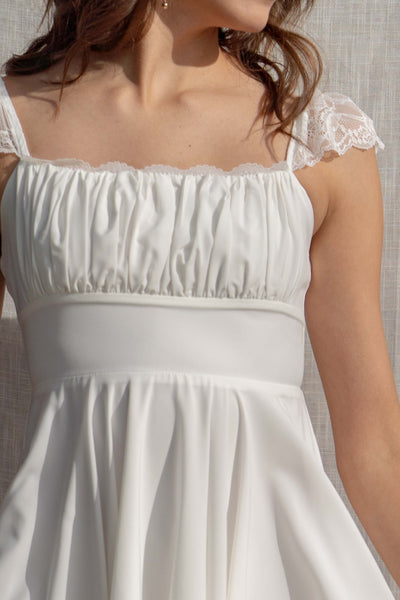 This mini dress features lace straps and trim, with a smocked bodice for a flattering fit.
