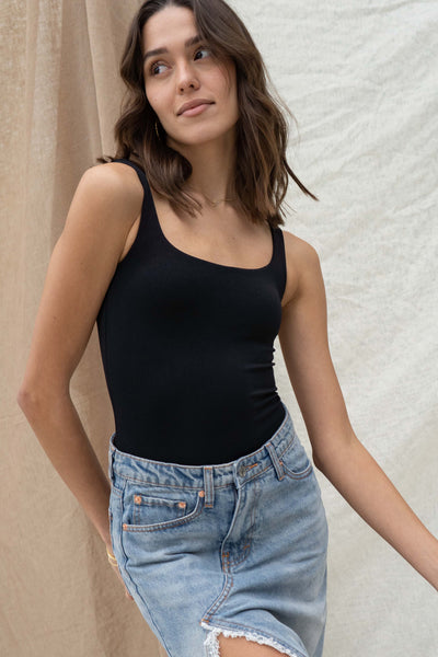 Bodysuit featuring a square neckline and a tank sleeve design, it is both fitted and versatile.