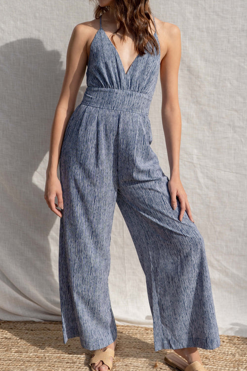 This versatile jumpsuit is both fitted and relaxed, making it perfect for any occasion. With a criss-cross open back and a light weight fabric.