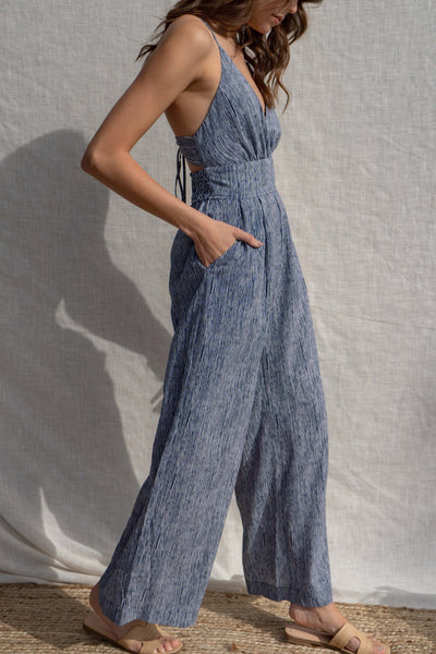 This versatile jumpsuit is both fitted and relaxed, making it perfect for any occasion. With a criss-cross open back and a light weight fabric.