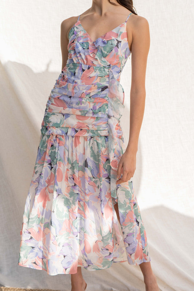 Featuring a beautiful floral water color print, thin straps, and delicate ruffle detail, you'll look chic and elegant in this fitted dress.