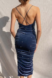 The elegant midi dress features a soft velvet material, delicate pearl details, and thin straps for a low back silhouette. navy color.