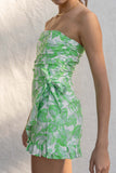 This stylish romper features a bright and bold tropical pattern, ruffle detailing around the hems, and a wrap detail for extra flair. Its strapless design ensures a comfortable fit while making a fashion statement. lime color.