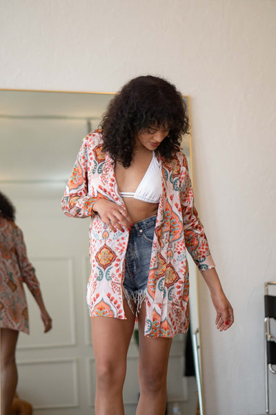 Featuring a satin button down, cuffed long sleeves, and a collared neckline eith boho print.