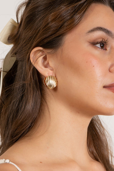 The unique seashell design and bold clasp detail make these earrings a statement piece . gold color.
